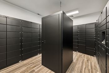 A room with black lockers and a wooden floor.